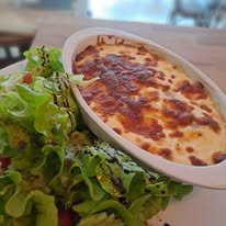 Gratin de cannelloni gratiné servi avec une salade