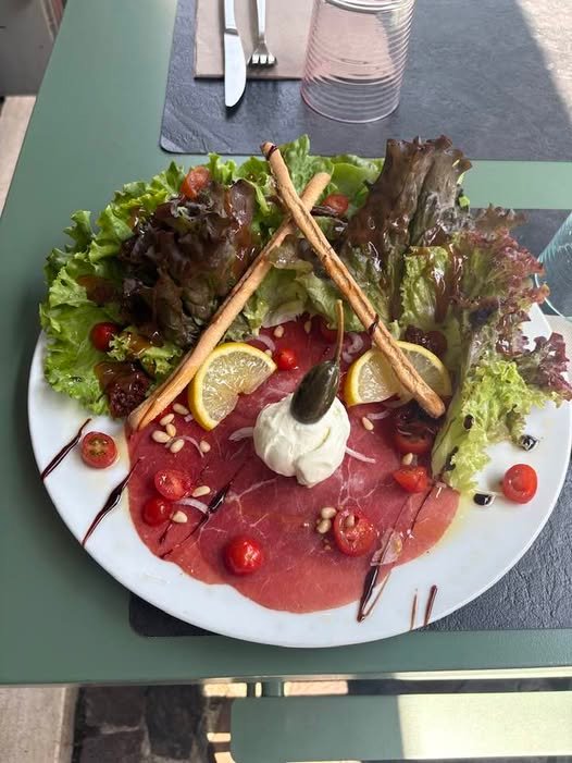 Carpaccio de bœuf, burrata et roquette dressés sur assiette